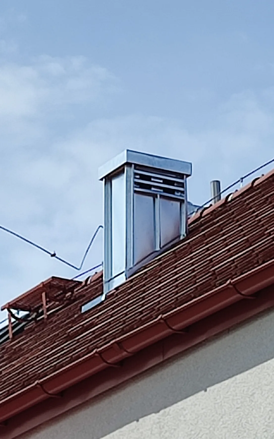 Gmina Kobierzyce: dekarz w akcji. W tym przypadku źle zrobione było nie tylko opierzenie ale również tynk na ścianach. Wykonaliśmy na miejscu panele na rąbek i zamontowaliśmy je wraz z opierzeniem i czapą na kominie. Teraz wystarczy zaczekać aż tytancynk spatynowieje 