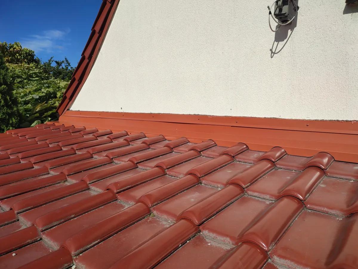 Wymiana obróbki przyściennej Wrocław. Przed naprawą woda lała się po ścianie do domu. Zbyt krótkie obróbki, odstające od pokrycia, bez odpowiednio zamontowanej opaski są źródłem przecieków z dachu.